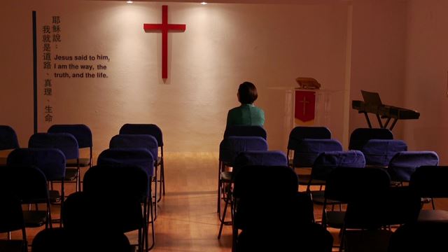 基督徒坐在荒涼的教會中